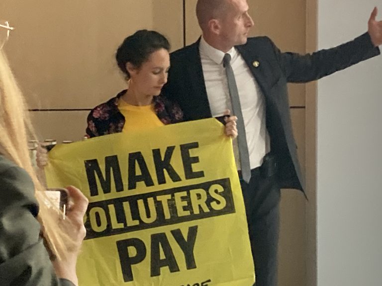 Environmental activist coming to the panel demanding polluters to pay taxes